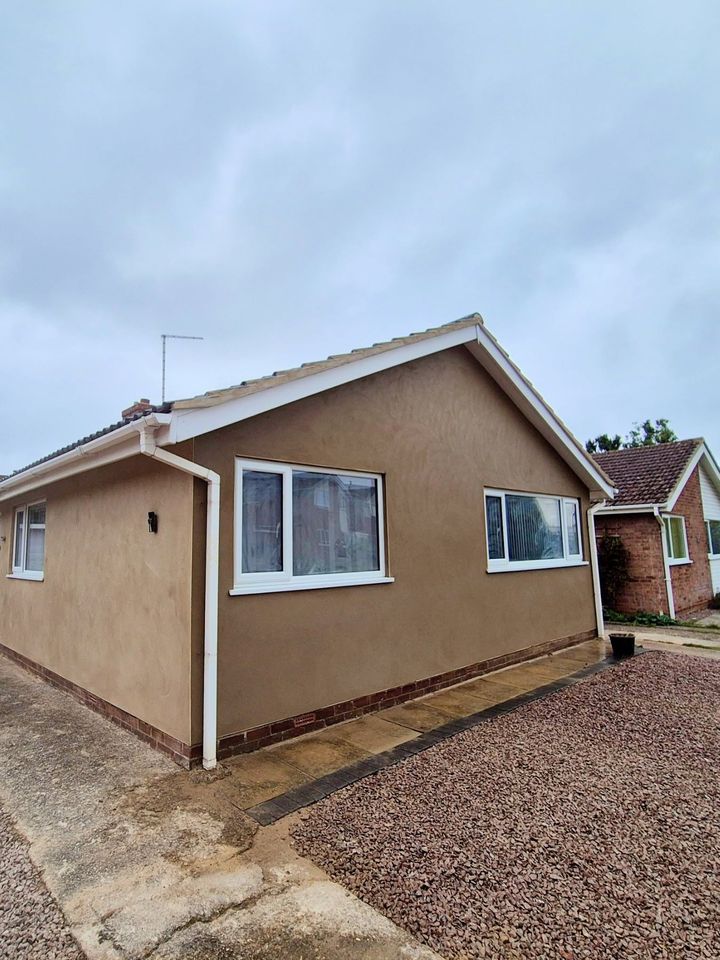 Freshly rendered bungalow with white windows and fascias